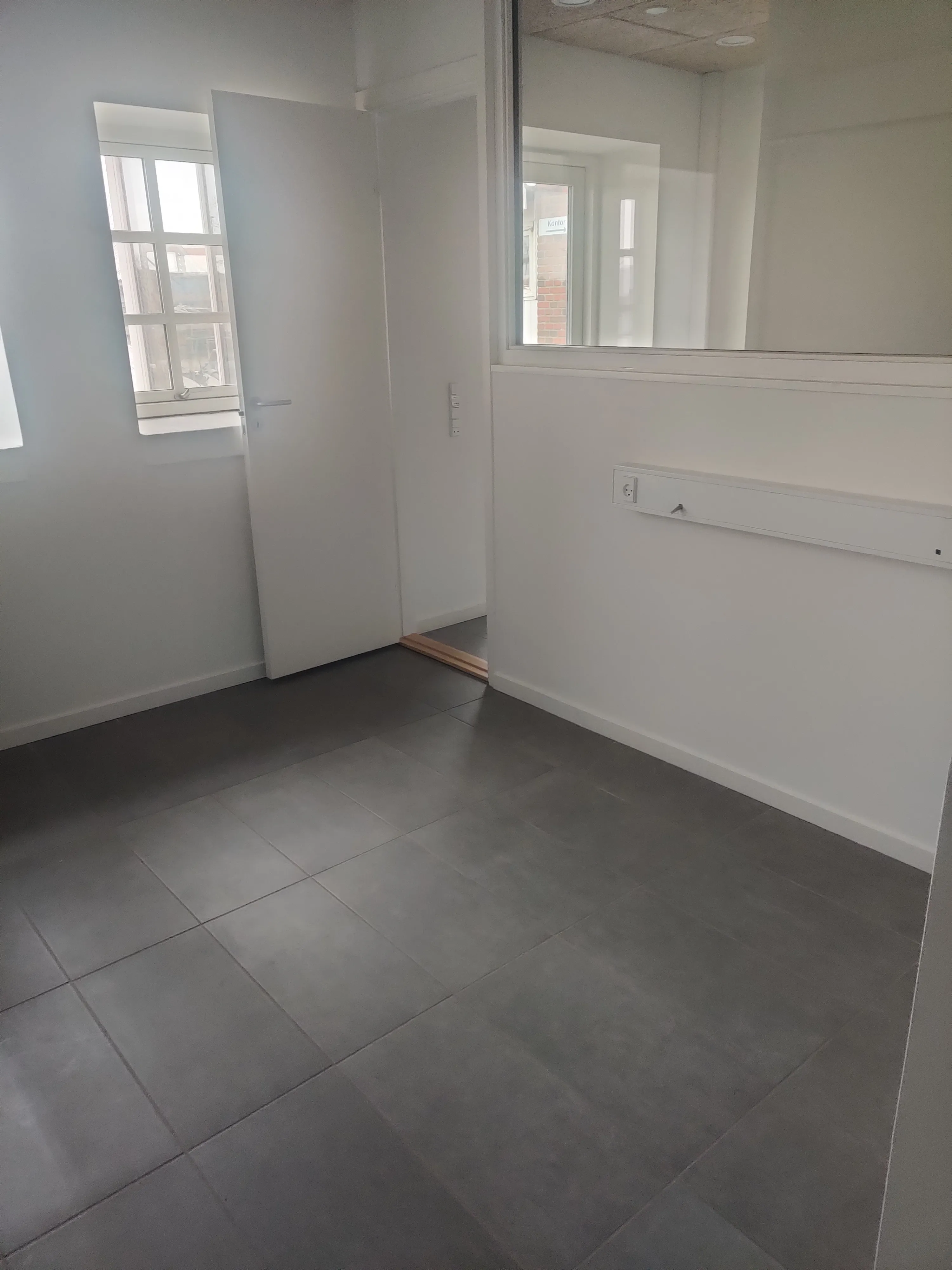 Et lyst og moderne kontorlokale med et skrivebord.